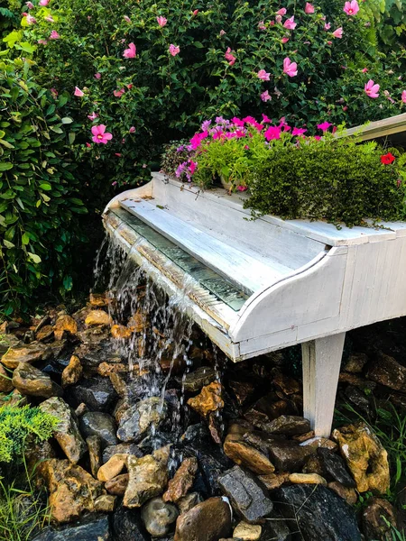 White grand piano water fountain in the summer garden