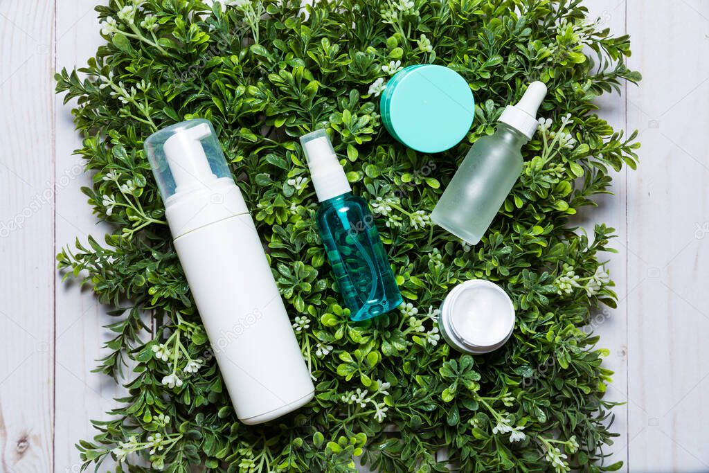 Variety of organic cosmetics on a green spring grass background