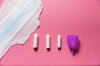 Parlak pembe arka planda kadın hijyen ürünleri. Regl konsepti