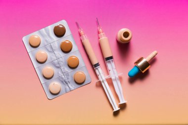 Makyaj önleyici ve fondötenle dolu su toplayan ilaç ve şırıngalar. Mükemmel cilt konsepti