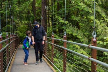 Koronavirüs salgını sırasında parkta yürüyüş yapan bir baba ve oğul.