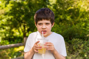 Sıcak bir yaz gününde limonata içen bir çocuk.