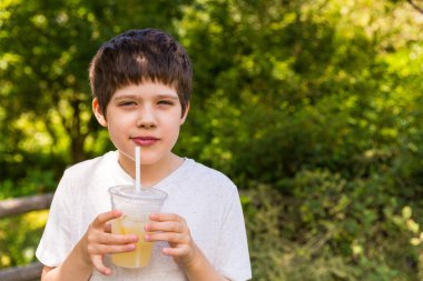 Sıcak bir yaz gününde limonata içen bir çocuk.