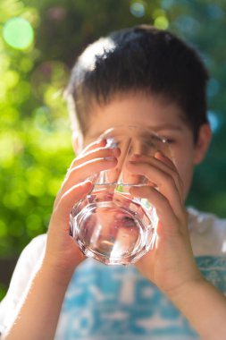 Sıcak bir yaz gününde su içen bir çocuk.