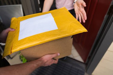Kapı eşiğinde bir kutu ve bir posta, online sipariş ev teslimatı konsepti