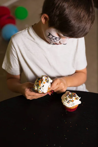 Niño Con Una Cara Pintura Comiendo Espeluznantes Cupcakes Halloween — Foto de Stock