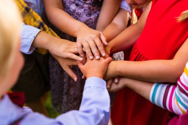 Çocuklar çemberde duruyor ve el ele tutuşuyorlar.