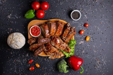 sosis ve kırmızı soslu pişmiş et, domates, kırmızı yeşil biber ve brokoli, ekmek, üst görünümü ile siyah arka plan üzerinde