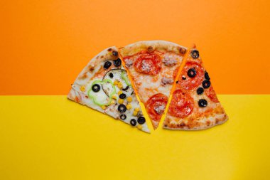 Üç farklı tatlar, sarı ve turuncu arka plan, dilimlenmiş biber, Üst görünüm ile İtalyan pizza. Banner, yakın çekim, kopyalama alanı