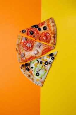 farklı pizza üç dilim, pepperoni, sarı ve turuncu arka plan, dilimlenmiş biber, Üst görünüm. Banner, yakın çekim, kopyalama alanı