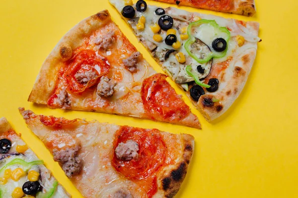 Set with different pizza slices, sliced peppers, yellow background, Top view. Banner, close-up, copy-space
