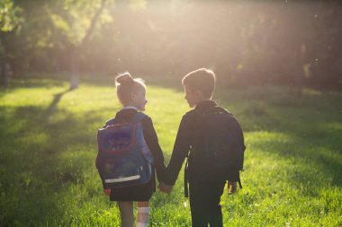 okul çocukları, okul çantası ile okul üniforması giymiş, okula dönen, açık, gün batımında