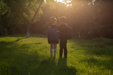 okul çocukları, okul çantası ile okul üniforması giymiş, okula gitmek, açık, gün batımında