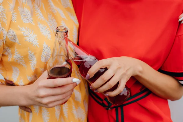 Close up. two hands with two bottles of drink, next to the car, outdoor — Stock Photo, Image