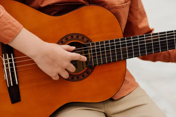 Gros plan, main d'enfant avec guitare, extérieur, guitare classique — Photo