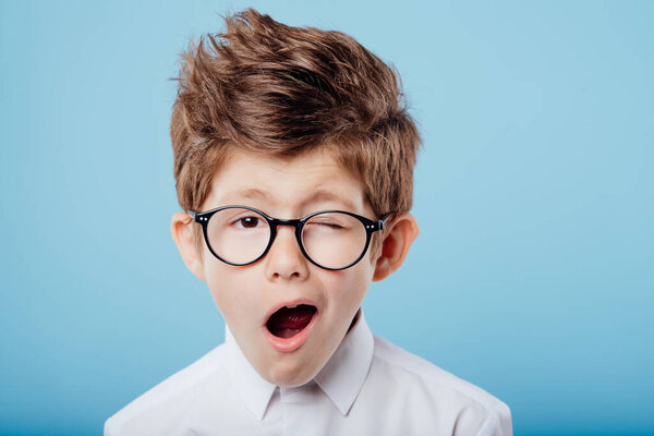 красивый ребенок в очках с открытым ртом, смотрит на камеру
,