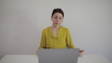 Gülümseyen beyaz kadın blogcu vlogger etkileyicisi ofiste oturuyor