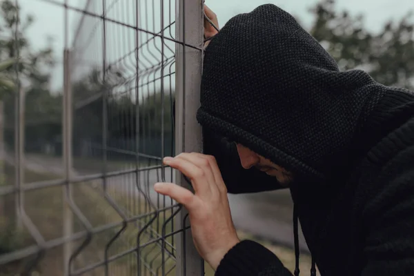 Самотній чоловік спирається на паркан — стокове фото