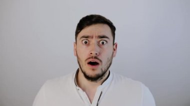 Şok olmuş genç adam kameraya bakıyor. 