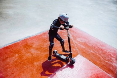 Çocuk scooter 'da numara yapıyor.