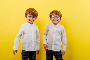 Sarı arka planda moda ikiz erkekler