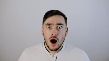 Şok olmuş genç adam kameraya bakıyor. 