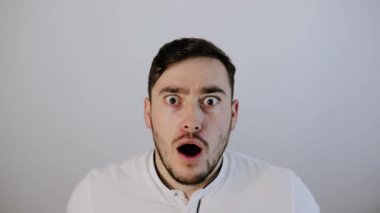 Şok olmuş genç adam kameraya bakıyor. 