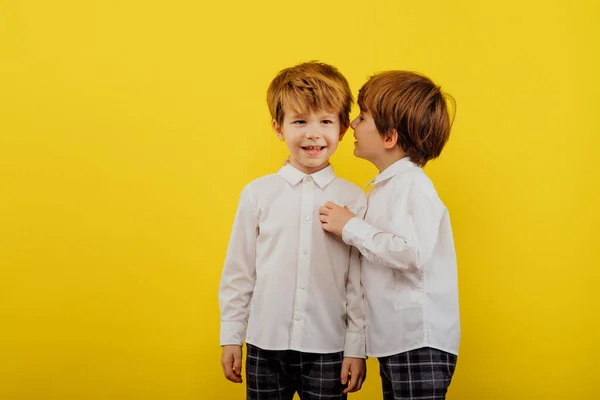 Два маленьких хлопчика обіймаються, граються, одягнені в білу сорочку — стокове фото