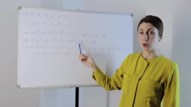 Evden çalışan genç öğretmen öğrencilere online matematik dersi veriyor.