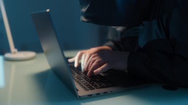 Bilgisayar korsanlarının klavyesine yazı yazarak siber dolandırıcılık, veri hırsızlığı ve bilgisayar korsanlığı tehditlerini vurgulayan bir yakın plan..