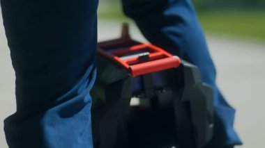 Genç bir adam sessiz bir park yolunda kendi dengesini sağlayan bir tekere biniyor. Yeşil titreşimler, mavi gökyüzü ve modern hareketlilikle dolu soğuk bir an..