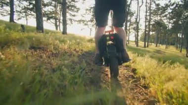 Ormanda tek tekerlekli bisiklete binmeyi seven bir adam. Güneş ışığı, ağaçlar ve temiz hava özgürlük ve hareket hissi uyandırıyor..