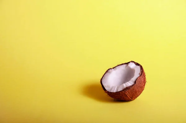 Meio coco no fundo amarelo. Comida Exótica. Conceito Tropical de Verão. Espaço de cópia para o seu texto — Fotografia de Stock