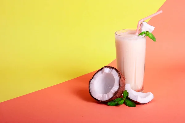 Pina Colada - Cocktail tropicale con succo d'ananas, latte di cocco e rum. Bevanda fresca estiva con Cracked Coconut e menta su sfondo corallo e giallo. Copia spazio per il testo — Foto Stock