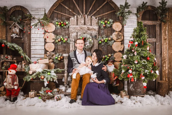 Navidad feliz familia de tres personas y abeto con cajas de regalo año nuevo fondo decorado invierno — Foto de Stock