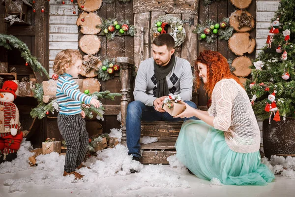 Navidad feliz familia de tres personas y abeto con cajas de regalo año nuevo fondo decorado invierno — Foto de Stock