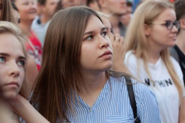 Samara, Rusya, 7 Temmuz 2018. FIFA Dünya Kupası, bir futbol fan bölgesinde maçı izlerken bir genç kız amigo