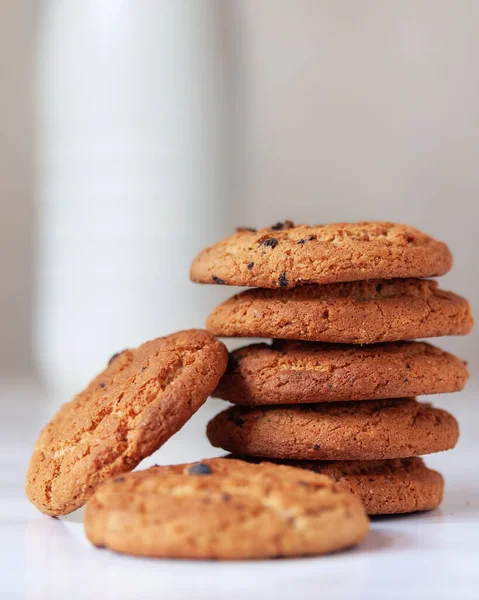 Kuru üzümlü klasik kurabiyeler ve arka planda bir şişe süt.