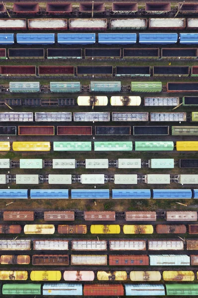 Veduta aerea dei treni merci sulla stazione ferroviaria. I treni merci in primo piano. Carri merci su rotaia. Scena concettuale industriale con treni. Vista dall'alto . — Foto Stock