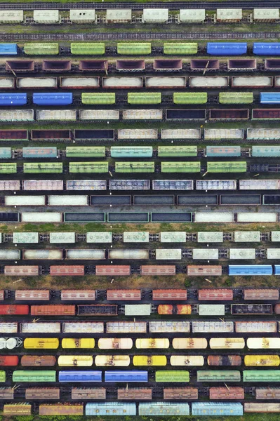 Vue aérienne des trains de marchandises sur la gare. Gros plan sur les trains de marchandises. Wagons avec marchandises sur le chemin de fer. Scène conceptuelle industrielle avec trains. Vue du dessus . — Photo