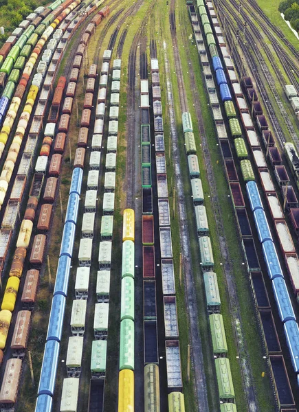 Veduta aerea dei treni merci sulla stazione ferroviaria. I treni merci in primo piano. Carri merci su rotaia. Scena concettuale industriale con treni. Vista dall'alto . — Foto Stock