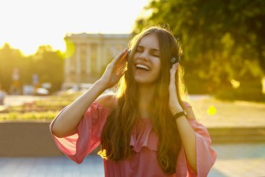 Gülümseyen genç kadın kulaklıkla müzik dinliyor. Neşeli hipster kız dinleme şarkı ile mutlu. Alan alanını kopyalama