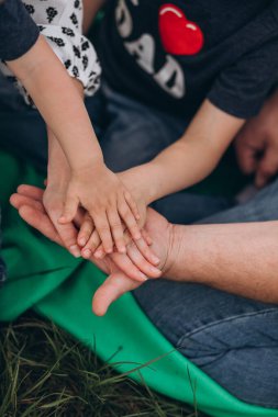 Aile birleşmesi kavramı. Ebeveynlerin ve iki çocuğun elleri