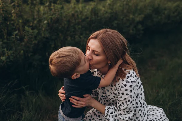 一个慈爱的年轻母亲和她的儿子玩耍 一起跑 亲吻和拥抱他 — 图库照片