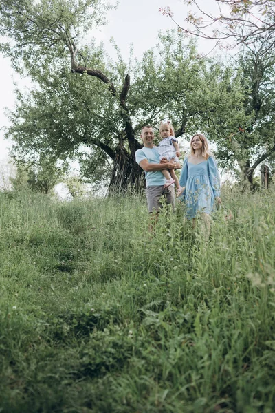 Genç Bir Aile Anne Baba Kız Ağaçlı Bir Bahçede Eğleniyorlar — Stok fotoğraf