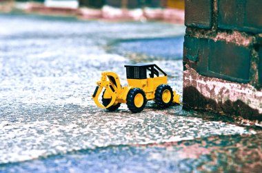 Oyuncak forklake ve tuğla sütun gölgeleri de çimento üzerinde gösterilir.