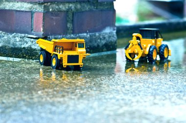 Orada kırmızı tuğla sütunlar ve kamyon ve folklene oyuncaklar çimento katında sular altında.