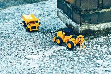 Orada kırmızı tuğla sütunlar ve kamyon ve folklene oyuncaklar çimento katında sular altında.