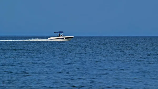 背景に山と海と青い空の高速船 驚くほどの白い高級ヨットの上でビュー グライド海の表面 美しい青い海の上に船の後白い波 観光や休暇の概念 — ストック写真
