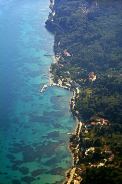 Masmavi deniz ve yeşil orman sahil şeridine güzel dikey görünümüne uçaktan
